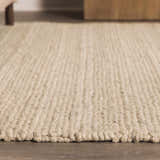 Close-up of Clarke Textured Braided Stripe rug. Dark beige wool rug with a chunky, hand-woven texture and braided detail. Roomscene-Rectangle
