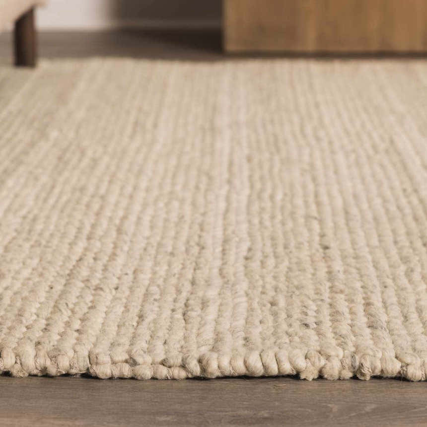 Close-up of Clarke Textured Braided Stripe rug. Dark beige wool rug with a chunky, hand-woven texture and braided detail. Roomscene-Rectangle