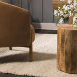 Living room scene with a brown chair and Clarke Textured Braided Stripe - Dark Beige Area Rug. Roomscene-Rectangle