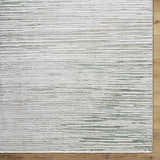 Close-up of the Corwin 3D Striped Washable Area Rug. Cream, gray, sage, and tan horizontal stripes. Contemporary style. Corner