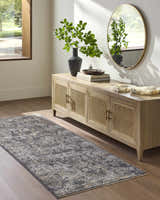 Entryway with a gray and tan Alexei Area Rug, wood floors, and a console table with a round mirror. Roomscene-Runner