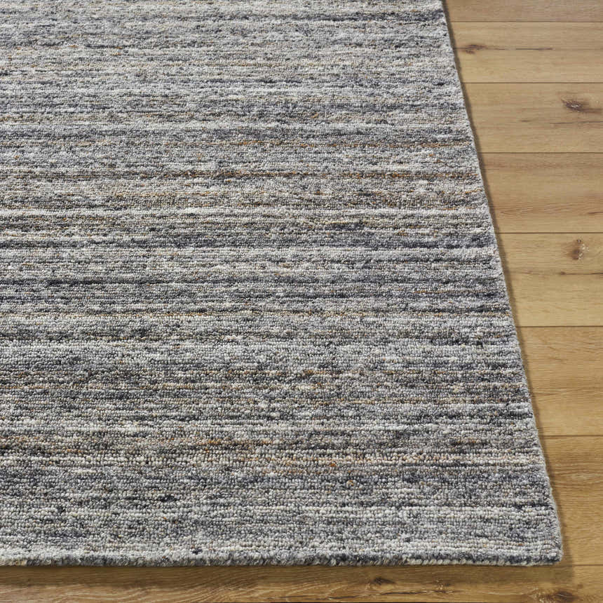 Close-up of the hand-tufted Capote Tan Area Rug showing its ash, charcoal, and tan tones and textured wool design. Front