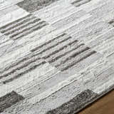 Close-up of the Chiaki Light Gray Area Rug, showing its ivory, light gray, and silver gray geometric pattern. Texture