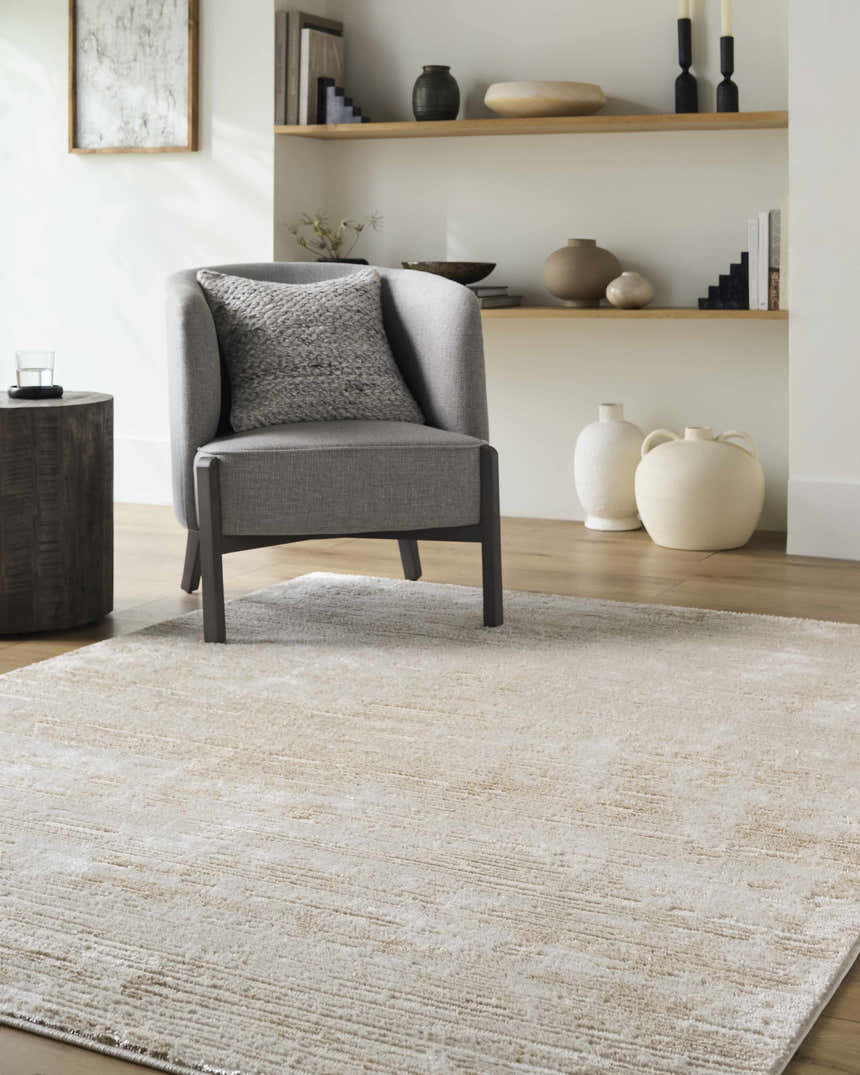 Living room scene with a gray chair on a Candie Beige Area Rug. The rug has a subtle contemporary design. Roomscene-Rectangle