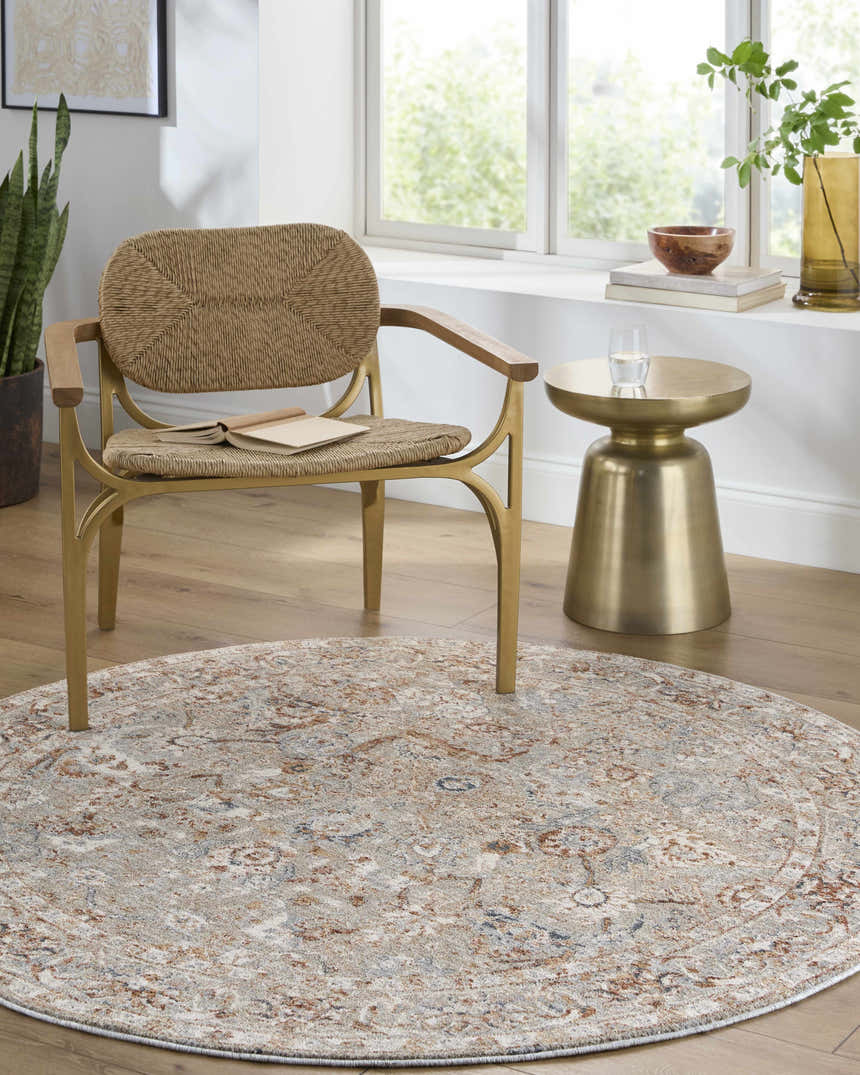 Sunlit room with a round Chikao Beige Area Rug, woven chair, and gold side table. Farmhouse style. Roomscene-Round
