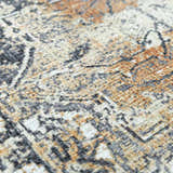 Close-up of the Dagatan Washable Area Rug. Beige, black, and camel farmhouse style rug with an oriental pattern. Texture