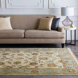Living room scene with a beige sofa and Dahlonega Area Carpet in beige, brown, and dusty sage. Roomscene-Rectangle