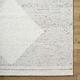 Close-up of Ethara Ivory Charcoal rug showing wool texture and global pattern on wood floor. Clearance. Corner