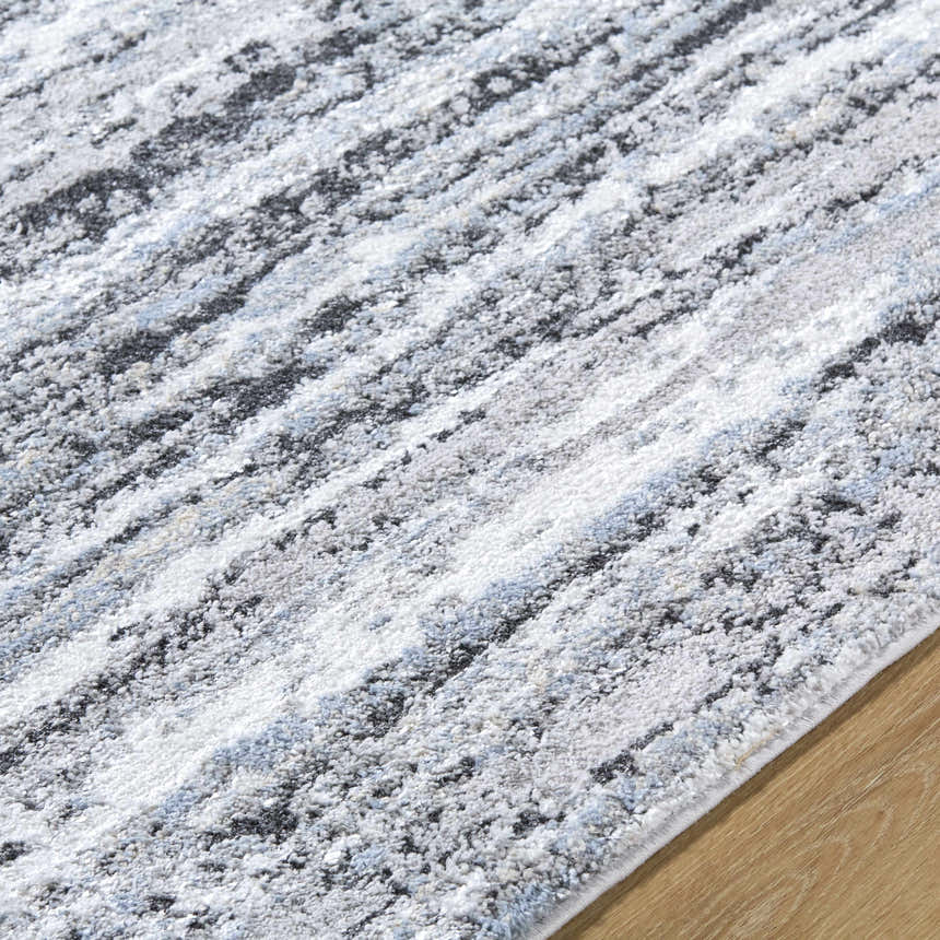 Close-up of the Azmina Area Rug. Contemporary design with black, ivory, light blue, and gray stripes. Machine woven texture. Texture