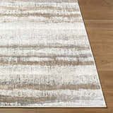 Close up of Asmara Brown area rug showing ash, pearl, and brown horizontal stripes on wood floor. Front