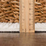 Close-up of the Kazuma Cream Checkered Washable Area Rug showing the pile height with a ruler. Cream and off-white tones. Pile