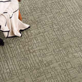 Close-up of Leanna Green Washable Area Rug showing its solid gray green color and geometric pattern and soft texture. Styleshot