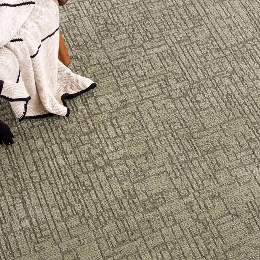 Close-up of Leanna Green Washable Area Rug showing its solid gray green color and geometric pattern and soft texture. Styleshot