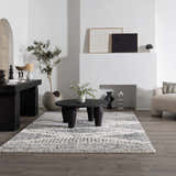 Living room scene with a charcoal and cream Santiago Area Rug under a round coffee table. Roomscene-Rectangle