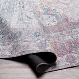 Close-up of the Livabliss Colin rug showing its farmhouse style, traditional pattern, and colors: charcoal, cream, dark red, and gray. Fold