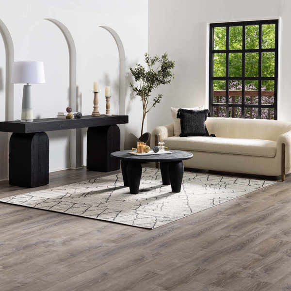 Living room scene with Ababuo Black Area Rug, cream sofa, black console table, and round coffee table. Modern, neutral tones. Roomscene-Rectangle