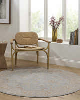Sunlit reading nook with Livabliss Avant Garde AVT-2371 round rug in gray, mustard, and taupe under a woven chair. Farmhouse style. Roomscene-Round