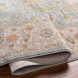 Close-up of the Livabliss Avant Garde AVT-2371 rug showing its traditional floral pattern in gray, taupe, mustard, and dark brown. Fold