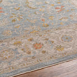 Close-up of the Livabliss Avant Garde AVT-2371 rug. Features a traditional floral pattern in gray, taupe, and mustard tones. Texture