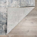 Close-up of the Eltham Thick Luxe Rug showing its gray, white, and blue contemporary design and woven texture. Fold