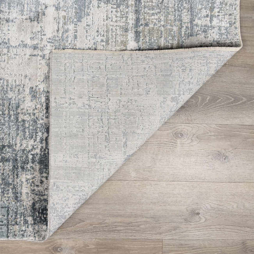 Close-up of the Eltham Thick Luxe Rug showing its gray, white, and blue contemporary design and woven texture. Fold
