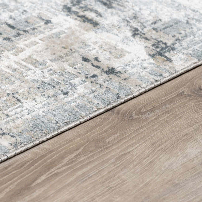 Close-up of Eltham Thick Luxe Rug in dusty sage, light gray, and navy on light wood flooring. Contemporary style. Corner