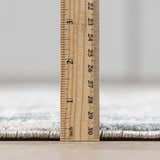 Close-up of Eltham Thick Luxe Rug showing its plush pile height with a ruler. Dusty Sage and Light Gray colors. Pile