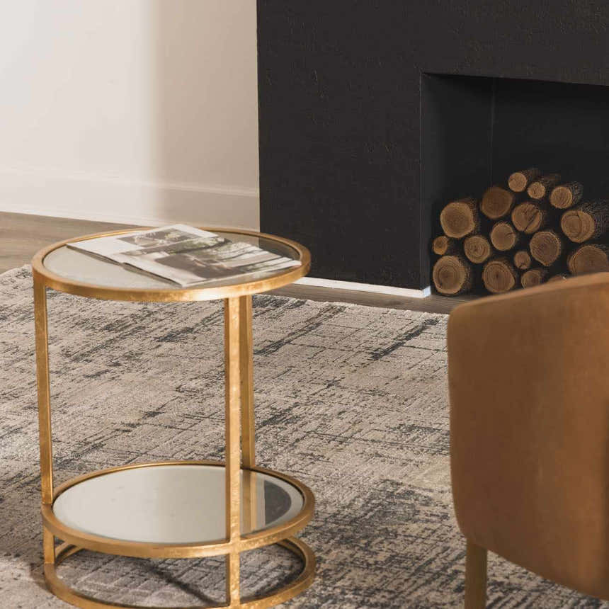 Living room scene with a neutral Eltham Thick Luxe Rug, gold side table, and black fireplace. Roomscene-Rectangle