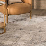 Close-up of the Eltham Thick Luxe Rug in light gray and taupe, styled with a leather chair and gold side table. Roomscene-Rectangle