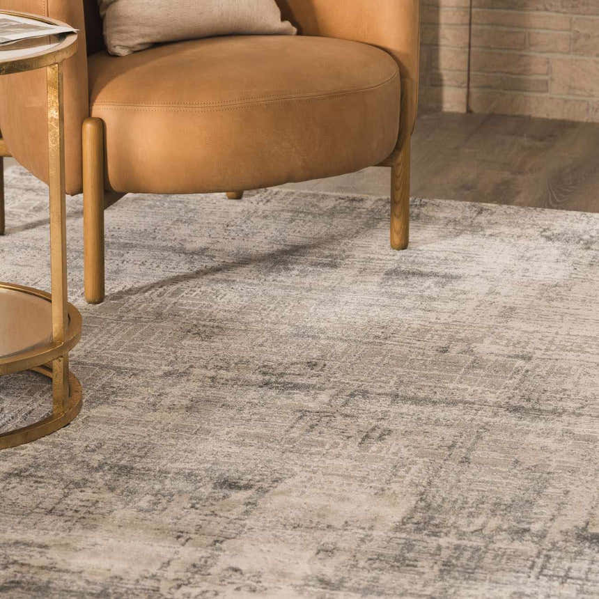 Close-up of the Eltham Thick Luxe Rug in light gray and taupe, styled with a leather chair and gold side table. Roomscene-Rectangle