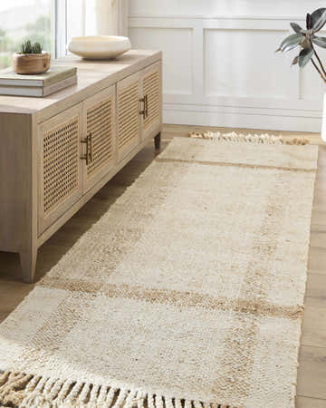 Entryway with a beige Errin Jute Area Rug runner, wood floors, and a light wood cabinet with decor. Roomscene-Runner