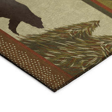 Close up of Dalyn Excursion EX1 Beige Washable Area Rug showing bear, tree design, brown dotted trim, and stitched edge.