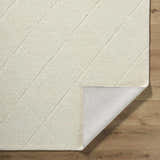 Close-up of the Almeda Washable Wool Area Rug in off-white, showing the hand-tufted texture and diamond pattern. Fold