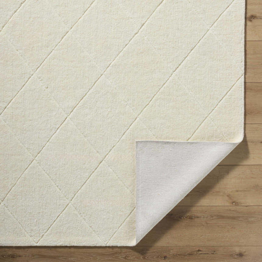 Close-up of the Almeda Washable Wool Area Rug in off-white, showing the hand-tufted texture and diamond pattern. Fold