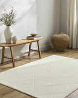 Farmhouse living room with off-white Almeda Washable Wool Area Rug, wood bench, and woven basket. Roomscene-Rectangle