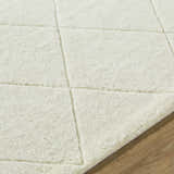 Close up of the off white Almeda Washable Wool Area Rug, showing the hand tufted texture and geometric pattern. Texture
