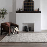 Living room scene with a Flintville Moroccan Shag Area Rug in charcoal and beige, styled with a brown chair and fireplace. Roomscene-Rectangle