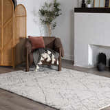 Living room scene with a charcoal and beige Flintville Moroccan Shag Area Rug under a leather chair. Roomscene-Rectangle