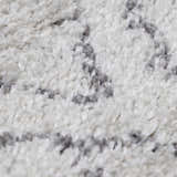 Close-up of the Flintville Moroccan Shag Area Rug. Soft, plush texture with a charcoal and light beige bohemian pattern. Texture