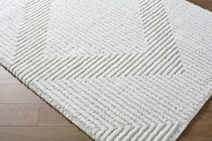 Close-up of the Ashlyn Cream Area Rug, a shag rug with a raised geometric chevron pattern. Corner