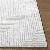 Close-up of the cream Ashlyn Area Rug showing its shag texture and subtle geometric pattern on a wood floor. Front
