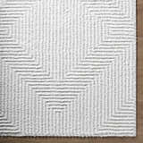 Close-up of the plush Ashlyn Cream Area Rug, showcasing its geometric shag design and soft, textured pile. Corner