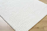 Close up of the cream Ashlyn White Area Rug with a subtle chevron shag design on light wood floors. Corner
