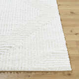 Close-up of the Ashlyn White Area Rug showing its shag texture and subtle geometric pattern on a wood floor. Front