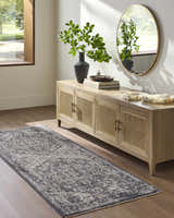 Entryway with Alissa Black Area Rug, wood floors, and a console table with a round mirror. Roomscene-Runner