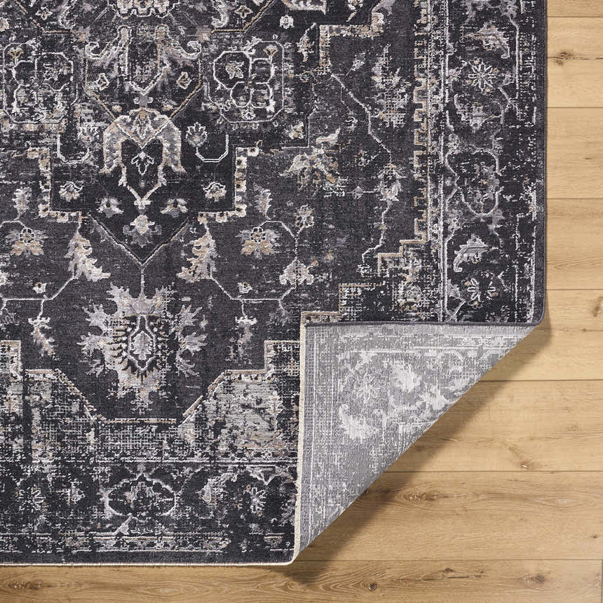 Close-up of the Alissa Black Area Rug showing its traditional, farmhouse design, colors, and machine-woven texture. Fold