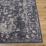 Close-up of the Alissa Black Area Rug. Traditional design in black, charcoal, gray, and ivory on a wood floor. Front