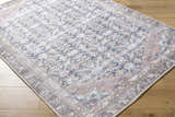 Close-up of the Ameera Washable Area Rug featuring a traditional, beige, black, and blue pattern on a wood floor. Corner