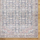 Close-up of the Ameera Washable Area Rug; a beige, black, and blue traditional rug with a farmhouse style pattern. Corner