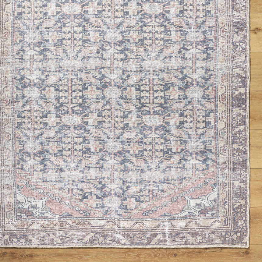 Close-up of the Ameera Washable Area Rug; a beige, black, and blue traditional rug with a farmhouse style pattern. Corner